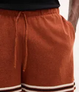 Bermuda masculina de jacquard color marrón tostado, con cintura elástica, bolsillos y detalle de franjas blancas en los dobladillos.