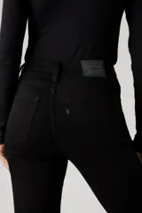 Jean de tiro alto con corte acampanado (flare), en color negro. Presenta un diseño clásico de cinco bolsillos y cierre frontal con botón y cremallera.