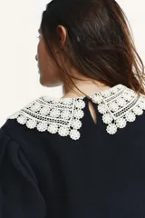 Jersey de punto color azul marino, con cuello de solapa en crochet color crema y manga corta abullonada. Cierre en la espalda con abertura y botón de perla.