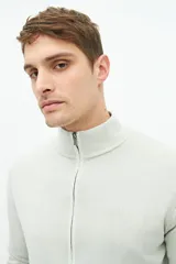 Campera tejida color verde militar, con cuello levemente elevado, cierre entero, logo bordado y fit regular.