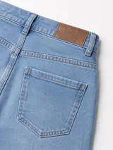 Jean de tiro alto con corte wide leg, confeccionado en denim con elastano. Presenta un lavado celeste suave, diseño de pierna extra amplia y cierre frontal con botón y cremallera.