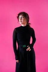 Remera de microtul negro con diseño ajustado, cuello alto y detalle de fruncido central vertical.