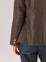 Blazer de denim estructurado con solapas clásicas, cierre frontal de un botón y bolsillos laterales con solapa. Presenta costuras visibles en contraste y un corte sastrero.