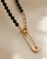 Set compuesto por collar y aros colgantes de acero con baño de oro, con diseño de dije en forma de alfiler de gancho.