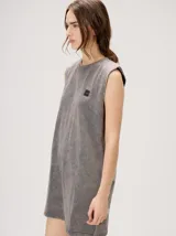 Vestido tipo remerón color gris con efecto acid wash, corte holgado, cuello redondo y sisas anchas con hombreras. Cuenta con bordado del logo en hilo oscuro en el pecho.