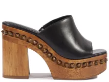 Zueco de plataforma Schutz color negro con taco alto de madera y detalles de tachas alrededor de la suela.