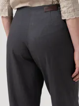 Pantalón gris de tiro alto y corte recto, confeccionado en mezcla de lana y poliéster reciclado. Presenta pretina limpia con cierre invisible lateral y un botón decorativo en el lateral.
