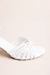Sandalia de taco cuadrado bajo color blanco, con múltiples tiras finas cruzadas en el empeine y tira ajustable en el tobillo con hebilla dorada.
