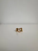 Anillo dorado de acero quirúrgico hipoalergénico, con diseño irregular y aberturas circulares.