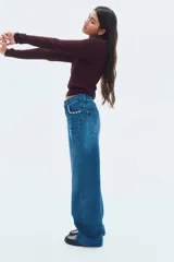 Buzo de tejido punto color bordó, con escote redondo pronunciado y manga larga. Presenta un diseño de punto trenzado a lo largo de todo el cuerpo y remates acanalados en cuello, puños y bajo.