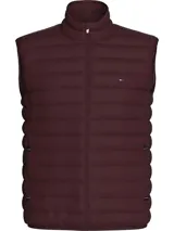 Chaleco acolchado Tommy Hilfiger de corte regular, con cuello levantado, cierre frontal de cremallera y dos bolsillos laterales con cierre. Presenta diseño con relleno, acabado repelente al agua y logo de la marca bordado en el pecho.