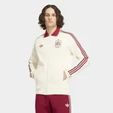 Campera deportiva Adidas Originals de la selección de España, color blanco con detalles en bordó. Presenta cuello tipo polo, cierre frontal con cremallera, las icónicas tres tiras en las mangas y el escudo de la selección junto al logo del trébol en el pecho.