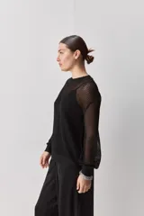 Sweater calado de punto negro, con cuello redondo y mangas largas, de diseño liviano ideal para superposiciones.