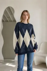 Sweater de tejido de punto con diseño de rombos en contraste, cuello redondo y mangas largas. Presenta una textura suave y un corte holgado.