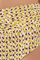 Calzón de bikini blanco con estampado de lunares amarillos y violetas, talle alto y faja cruzada al frente y atrás.