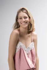 Pijama de satén elastizado color champagne, compuesto por musculosa con escote en V y detalle de puntilla elastizada, y short con elástico en la cintura y terminación con puntilla.