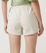 Short runner color beige, de cintura media con elástico y lazo ajustable. Confeccionado en algodón y lino, con bolsillos laterales.