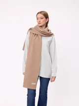 Bufanda de tejido de punto grueso en color negro, con etiqueta de la marca Rusty en uno de los extremos.