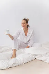 Pijama de dos piezas confeccionado en popelina de algodón. Incluye una camisa de manga larga con cuello smoking, cierre frontal abotonado y detalles de vivo en contraste en cuello, puños y solapas. El pantalón cuenta con cintura elástica, bolsillos laterales y detalles de vivo en los bajos.