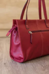 Cartera tipo shopper de cuero genuino marrón con panel central de textura símil cocodrilo y herrajes metálicos plateados.