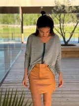 Pollera corta de cuero ovino color suela, con diseño de paneles y costuras visibles, cierre frontal y bolsillos laterales.