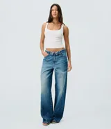 Pantalón wide leg de jean para mujer, con tiro medio, cintura doblada, costura lateral desplazada y bolsillos delanteros y traseros. Confeccionado en algodón certificado.