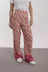 Pantalón de mujer con estampado floral en tonos rosa y rojo, de corte palazzo y cintura alta.