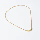 Collar dorado con cadena fina y dije de cuentas cúbicas.