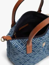 Cartera tote compacta Tommy Hilfiger de tejido denim con estampado geométrico integral del monograma TH, asas superiores en tono marrón y correa de hombro ajustable y extraíble. Cuenta con cierre de cremallera y herrajes dorados.