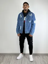 Campera de jean celeste con roturas y desgaste.