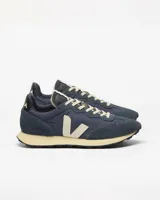 Championes Veja modelo Rio Branco II, color azul marino con detalles en beige y negro. Confeccionados en una combinación de paneles de gamuza y tejido técnico, con el logo lateral en forma de V en color crema y suela de goma en tono amarillento.
