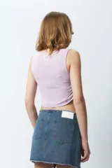 Top cropped color lila sin mangas y cuello a la base, con frunces en ambos laterales.