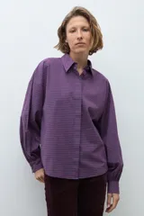 Camisa de manga larga con estampado de cuadros pequeños en tonos violeta y rojo, con cuello clásico y cierre frontal de botones.
