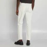 Pantalón chino de hombre, color blanco crudo, de corte slim y tiro medio, con cinco bolsillos y cierre de cremallera.