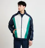 Campera deportiva Ellesse modelo Sako, diseño en bloques de color azul marino, blanco y verde, con cierre frontal completo, cuello alto y detalles de líneas blancas en las mangas.