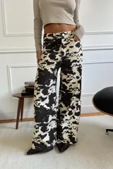 Pantalón de gabardina rígida con estampado de manchas blancas y negras, corte wide leg y tiro medio.