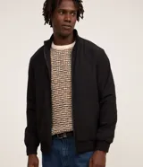 Campera bomber Marfinno para hombre, de color negro, confeccionada en poliamida con elastano y forro de poliéster. Cuenta con cuello alto, cierre frontal por cremallera y elástico en puños y cintura.