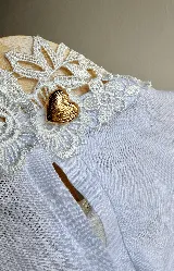 Blusa blanca de lino con cuello Galón estructurado y detalle de encaje.