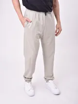 Pantalón de jogging color beige, con cintura elástica ajustable mediante cordón y puños elásticos en los tobillos.