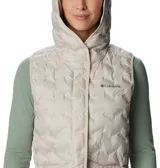 Chaleco acolchado Columbia con capucha, color beige, con cierre frontal y bolsillos laterales con cremallera. Presenta tecnología de sellado térmico y logo de la marca bordado en el pecho.