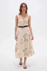 Vestido midi de viscosa color beige con estampado de hojas en tonos verdosos, de corte holgado, con tirantes finos regulables y escote cuadrado.