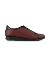 Zapatillas de cuero napa color bordó, con cordones y suela anatómica de goma negra. Presenta detalles en color negro en la cordonera, el borde superior y el talón.