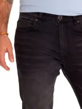 Jeans slim de corte ajustado en color gris oscuro con efecto deslavado, diseño de cinco bolsillos y un leve roto en la rodilla derecha.