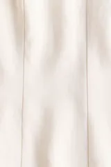 Blusa blanca de manga corta con escote redondo, costuras moldeadoras y diseño peplum acampanado con cierre trasero de botón.