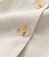 Chaleco color crudo confeccionado en viscolino, con escote en V, botones color carey y bolsillos delanteros.