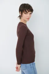 Buzo de tejido morley color marrón, con cuello redondo y mangas largas, de corte ajustado al cuerpo.