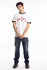 Remera ringer blanca con cuello y bordes de mangas en color negro. Presenta un estampado frontal en color rojo con caracteres estilizados y una estrella central.