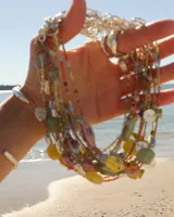 Collar corto de cuentas de colores con dije de pez de cerámica, piedras naturales y detalles en plata 925.