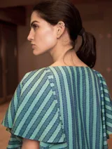 Vestido midi con estampado a rayas verticales en tonos verde oliva, gris y blanco. Tiene cuello redondo y mangas cortas amplias tipo volado.