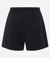 Short pollera de sastrería marca Cortelle, color bordó, confeccionado en crepé. Presenta sobreposición frontal efecto pollera con pliegues y detalle de cadena metálica decorativa en el lateral.